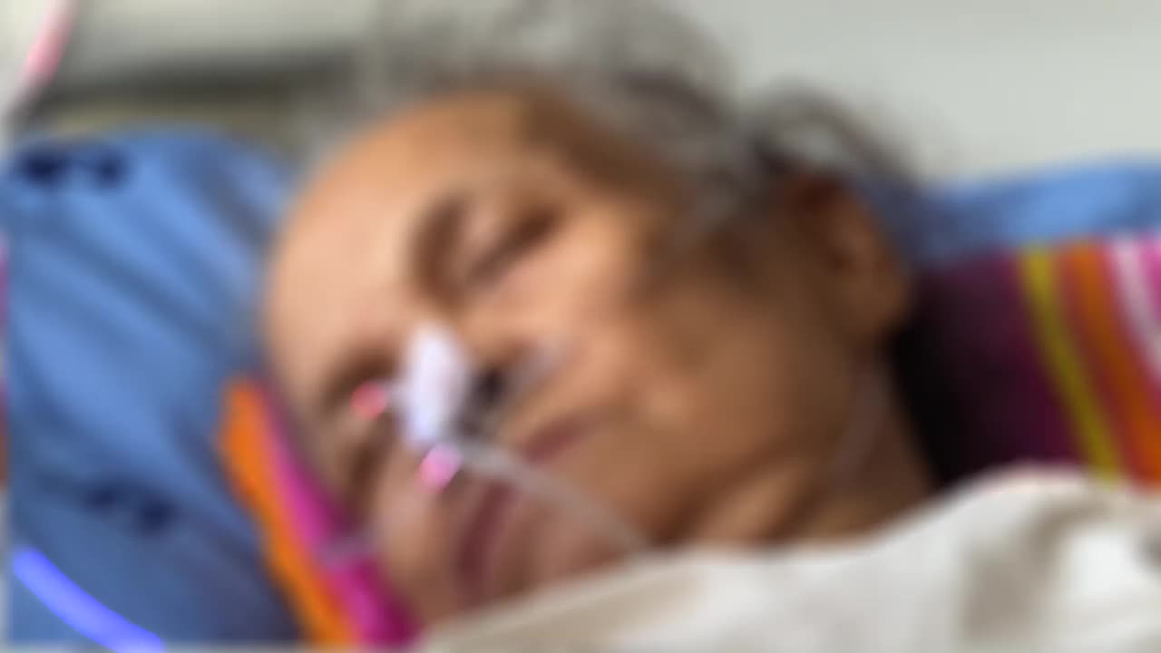 老年女性患者在病床上用血氧计视频下载