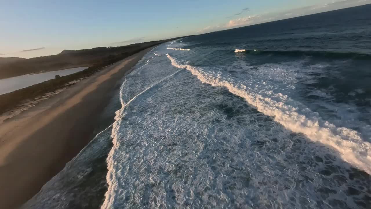 日落时分，低空鸟瞰海浪。视频下载
