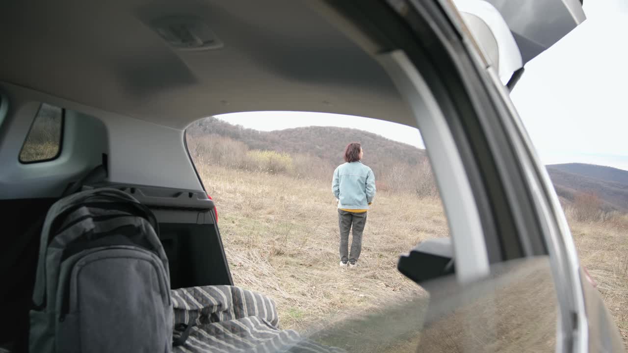 一位年轻女子在独自驾车旅行时欣赏风景。视频素材
