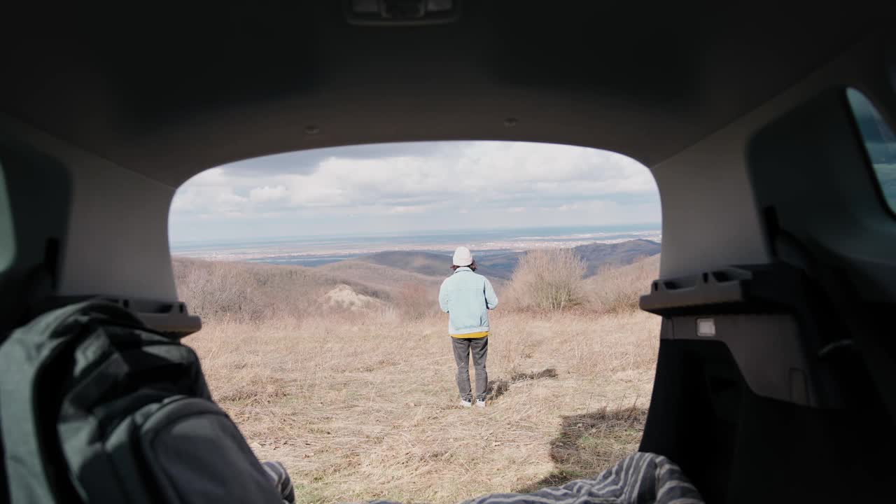 一位年轻女子在独自驾车旅行时欣赏风景。视频素材