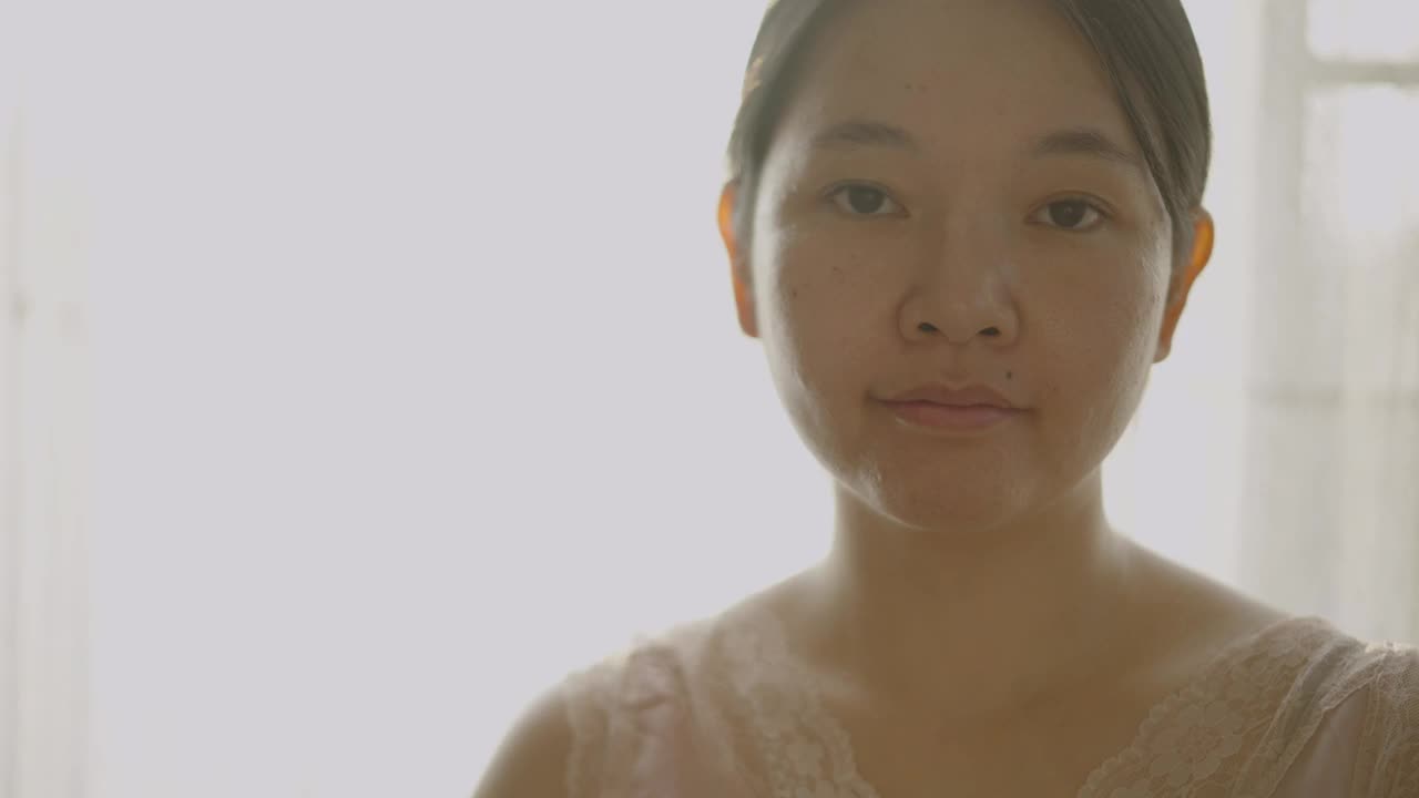 亚洲女性喜欢在脸部和颈部涂抹润肤霜和护肤品。视频下载