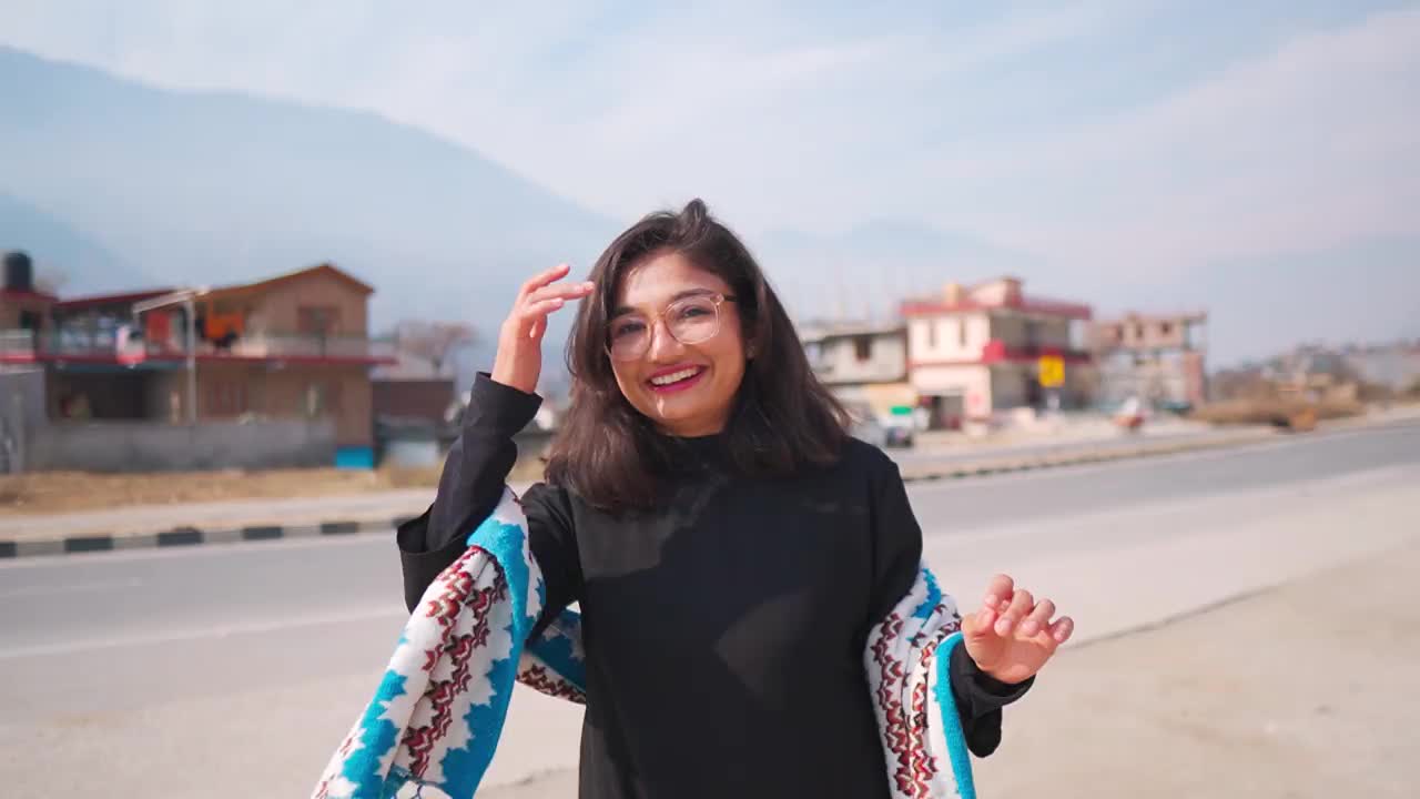 印度喜马偕尔邦马纳利，一名自信的年轻印度女子站在路边拍视频。社交媒体影响者内容创造者的生活方式。视频下载