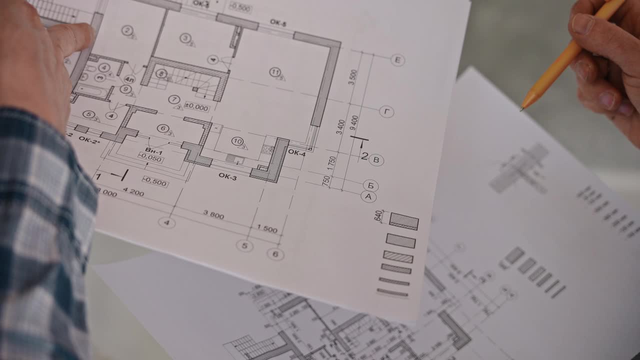工程师和建筑工人根据详细图纸讨论房屋工程。在建筑工地工作。开发人员视频下载