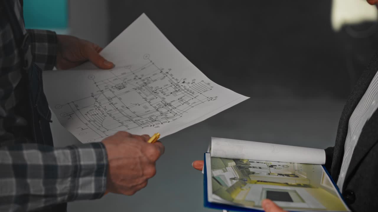 一个男人和一个女人正指着纸上的房子蓝图视频下载