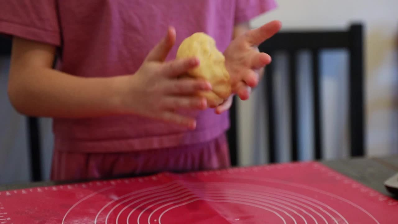 这个女孩用手揉面团。视频下载