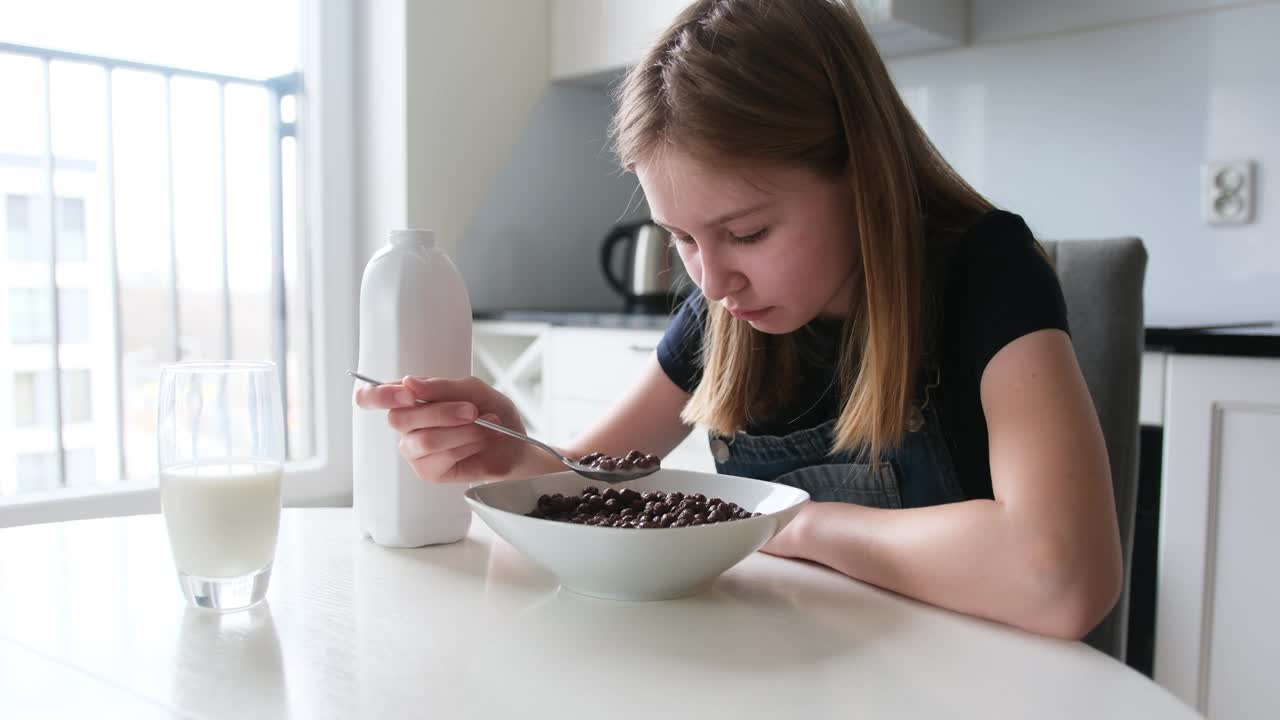 女孩早上在厨房吃着棕色巧克力球干早餐视频下载