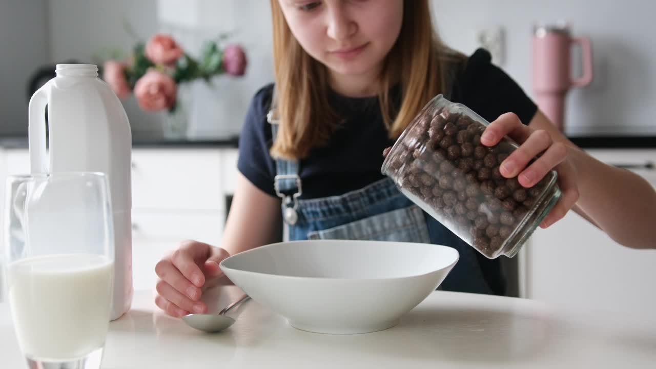 女孩在厨房里把棕色巧克力球倒进盘子里视频下载