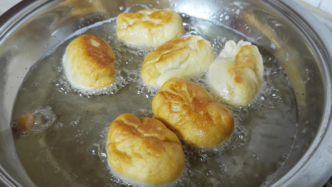 自制的小馅饼在沸油中煎。视频下载