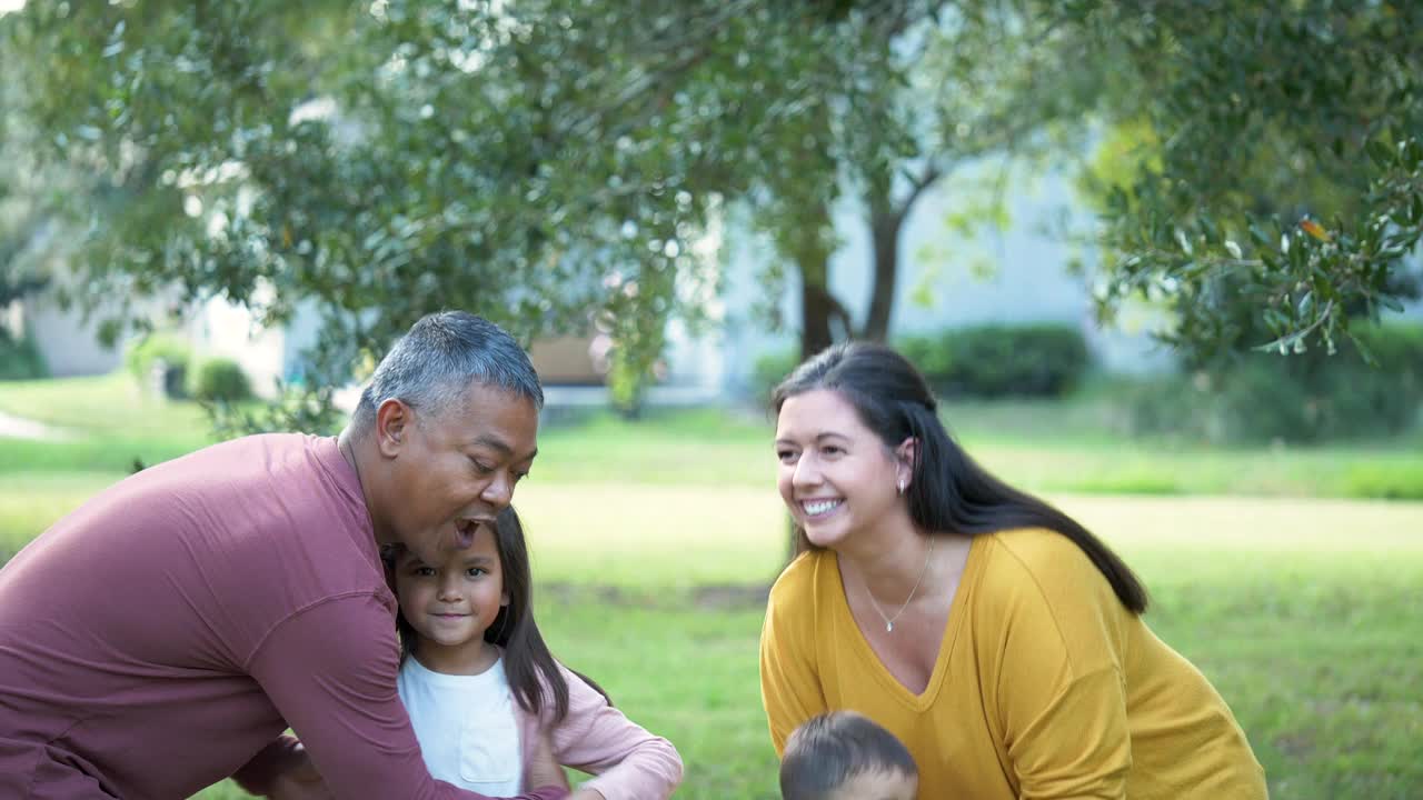 多种族的父母抱起孩子，对着镜头微笑视频下载