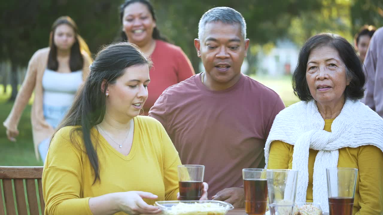 多代多种族家庭在后院吃饭视频下载