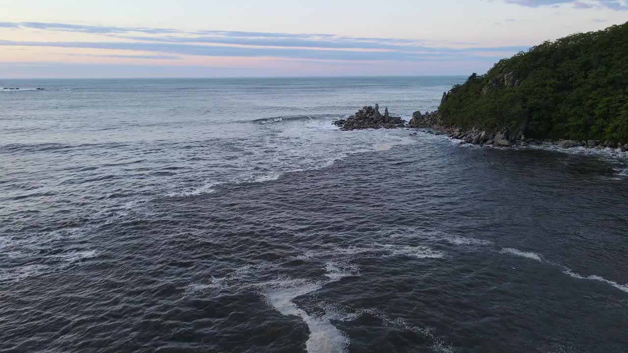海浪拍打着岩石海岸，形成了引人注目的自然景观视频素材