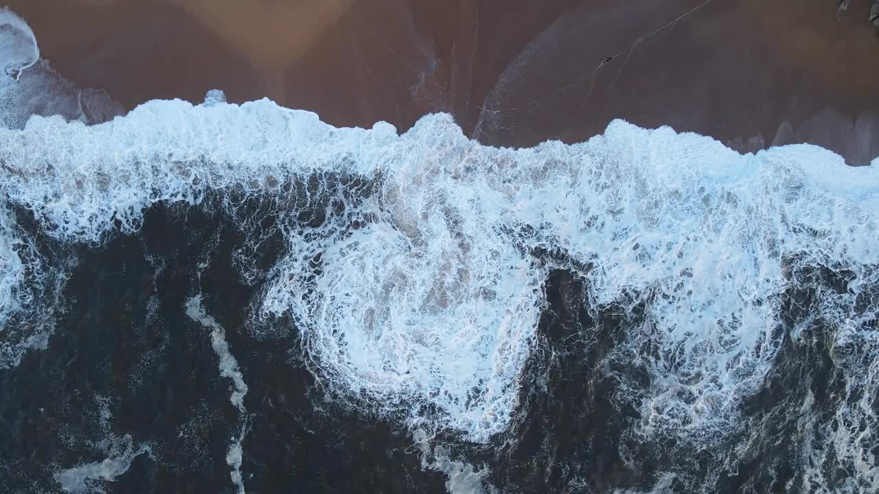 空中冰冻水事件显示冬季岩石海滩上的波浪模式视频素材