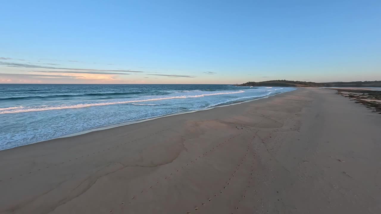 夕阳下沙滩上的低空鸟瞰图。视频下载