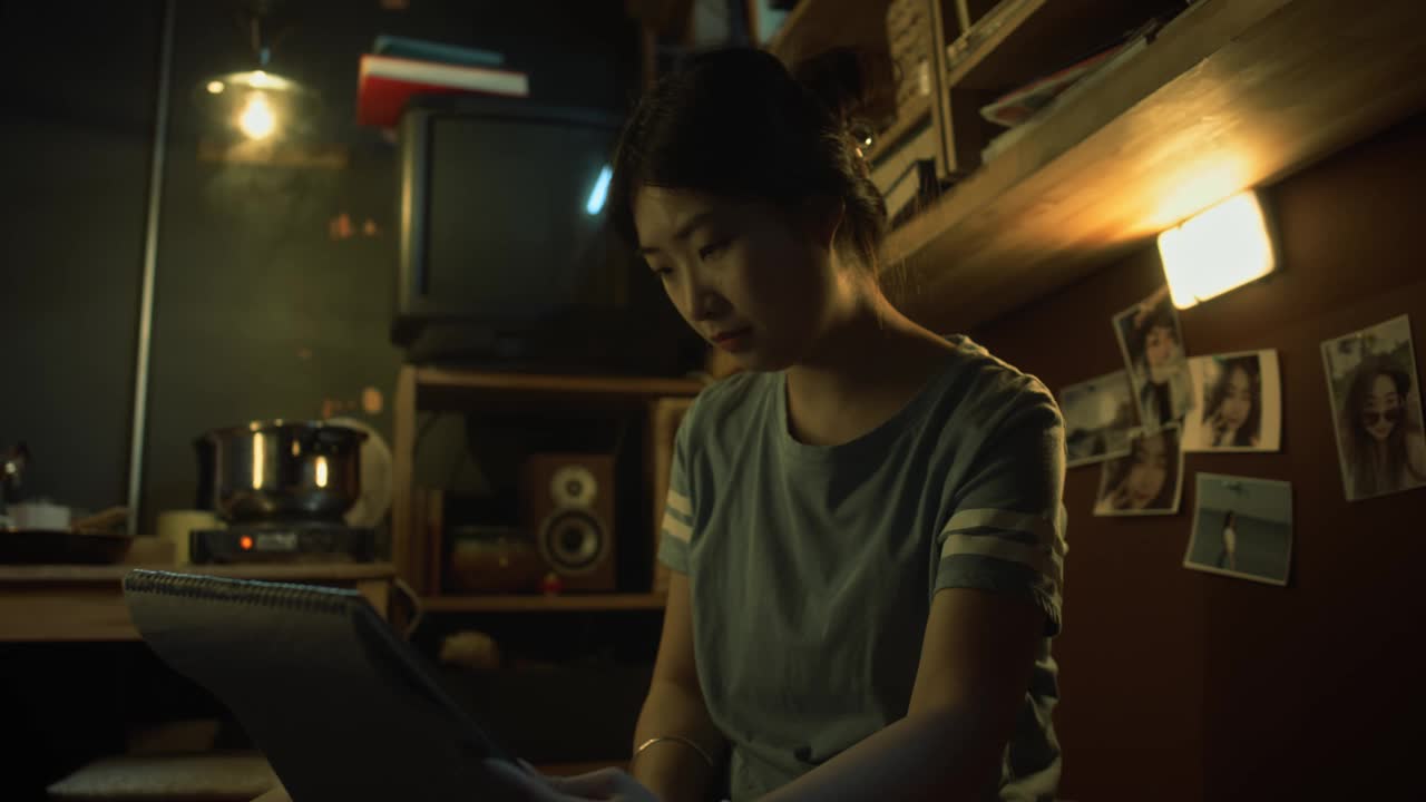 年轻的亚洲女艺术家在黑暗的小公寓里画静物素描视频下载
