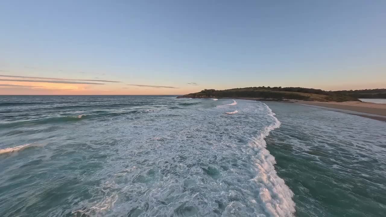 夕阳下沙滩上的低空鸟瞰图。视频下载