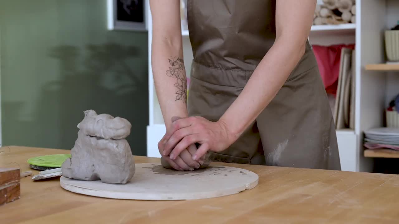 年轻的女工匠捏捏软粘土，使其成形。最喜欢的爱好视频下载