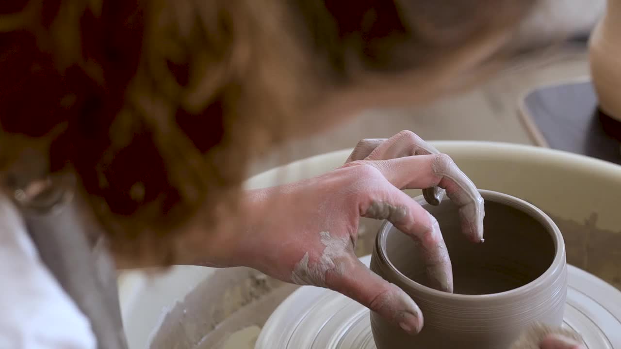 在车间里，陶工的双手温柔而自信地在陶工转盘上形成陶罐视频下载