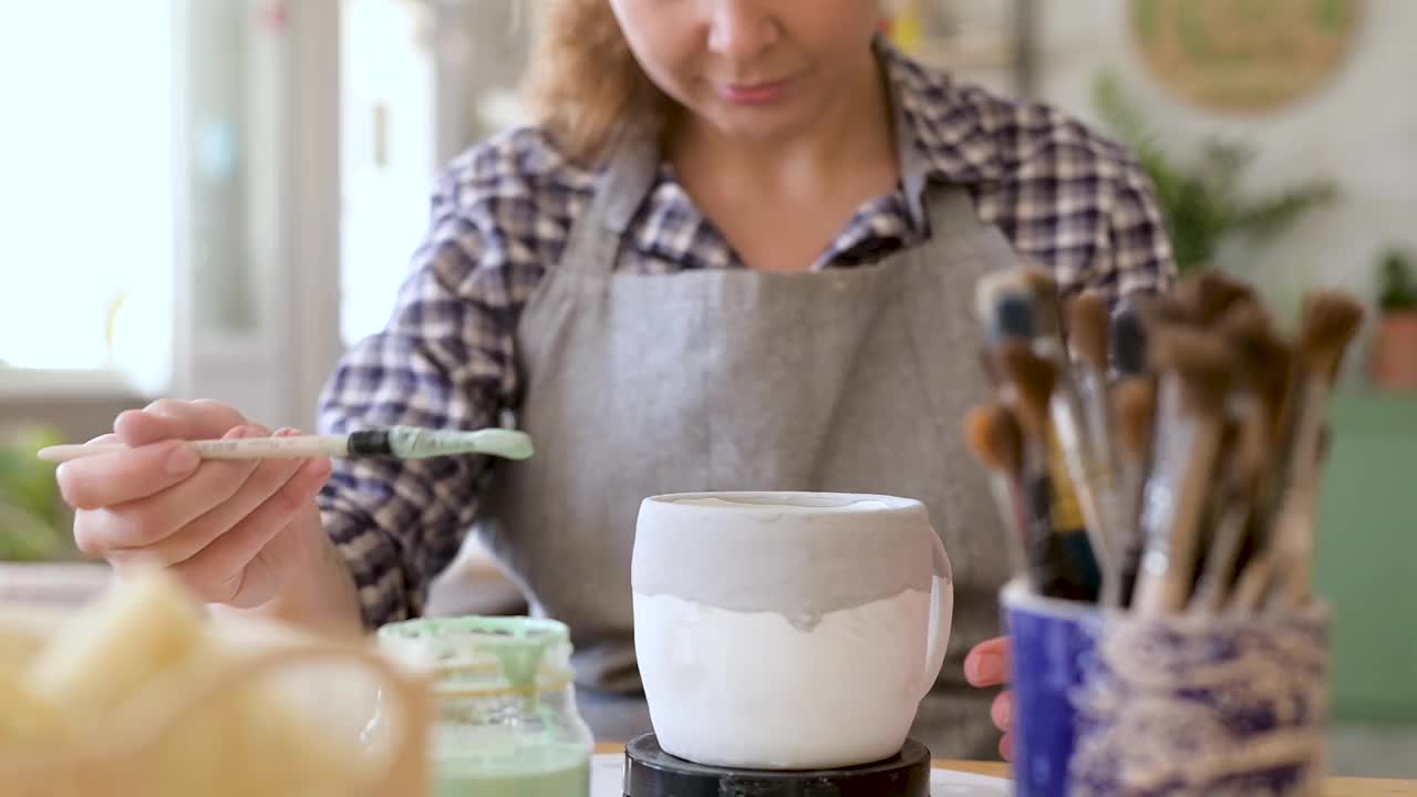 工艺大师使用彩色搪瓷陶瓷杯。制作手工陶瓷视频下载