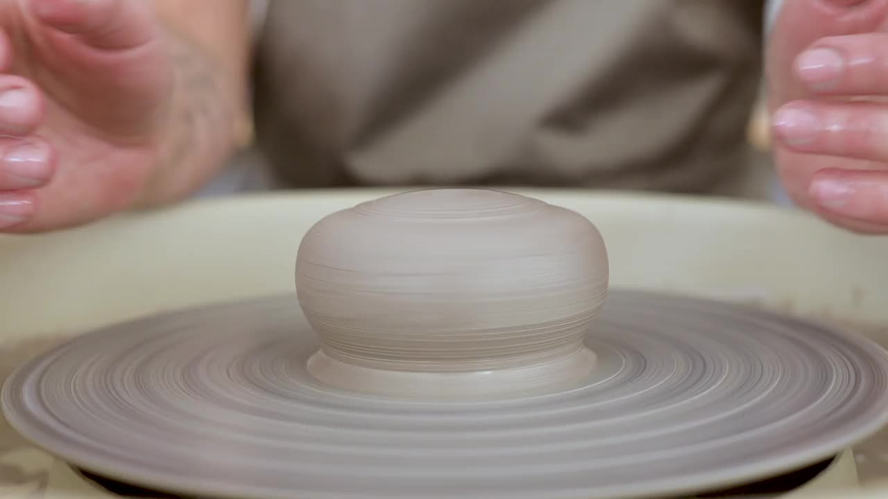 女工匠用粘土在陶器上塑形。陶工的手塑造粘土的特写视频下载