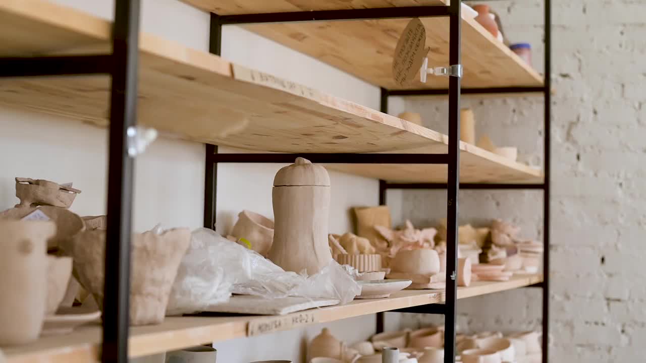 一名年轻的女工匠在陶器作坊里把陶瓷制品放在篮子里视频下载