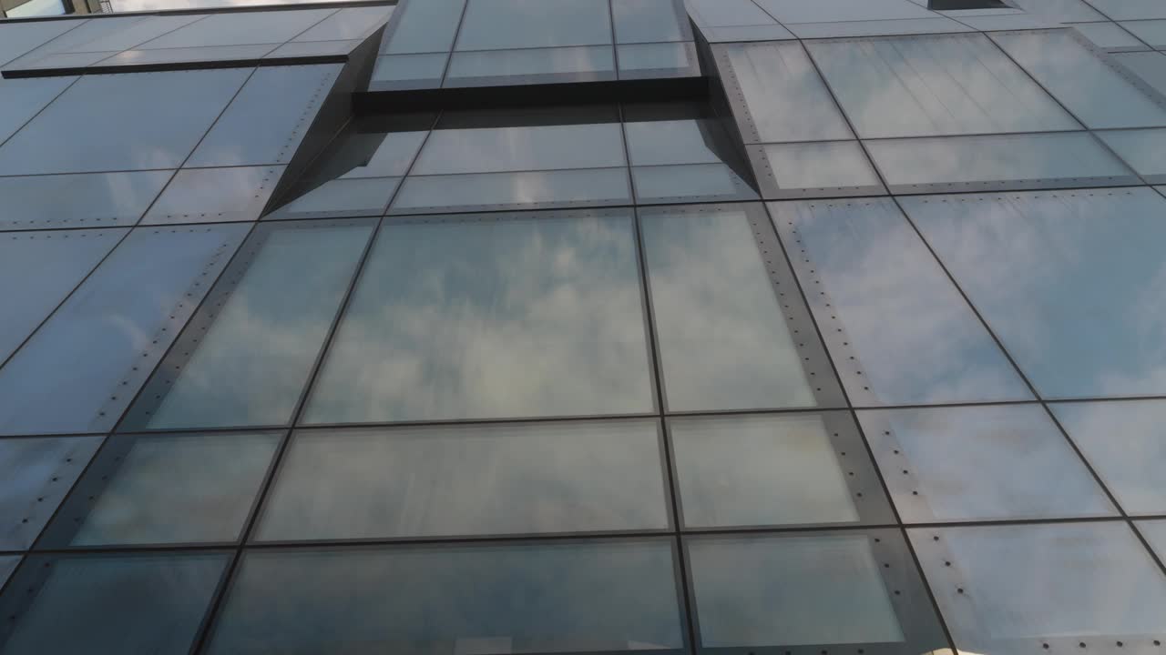 跟随云反射在现代办公大楼的大玻璃窗上视频下载