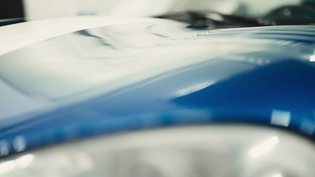 一辆闪亮的蓝色跑车模型的详细照片。反光的汽车表面。视频下载