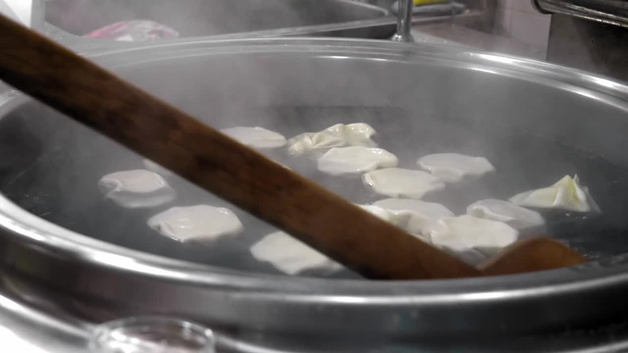 在厨房用沸水和蒸汽在大锅中烹煮khinkali视频下载