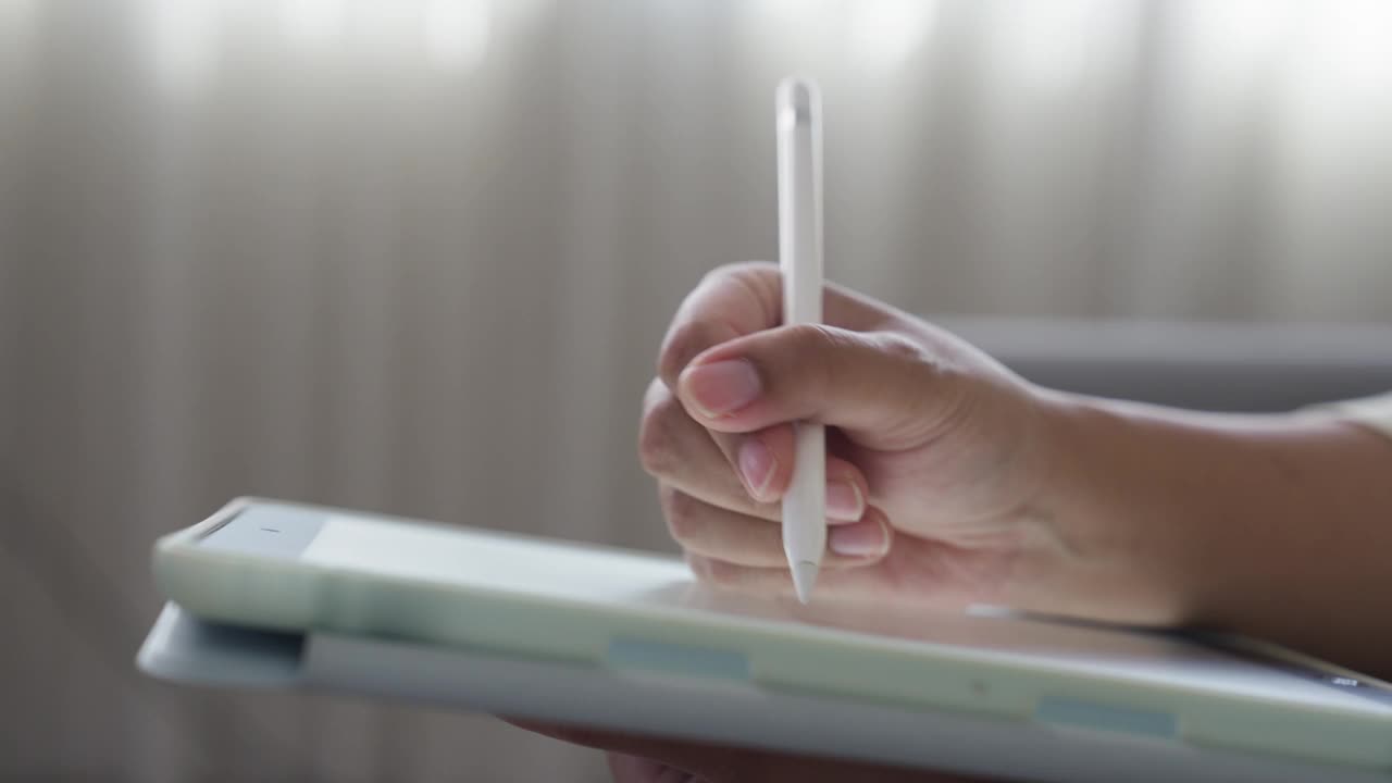 女性用数字笔在数字平板电脑上书写或绘图的特写视频下载