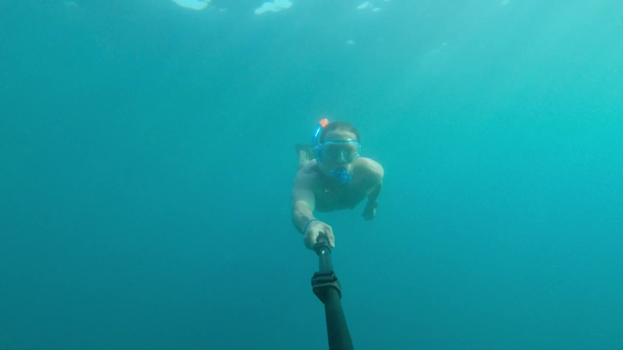 一位游泳健将白人男子在水下自拍。自由潜水和放松的概念在海边或海洋视频素材