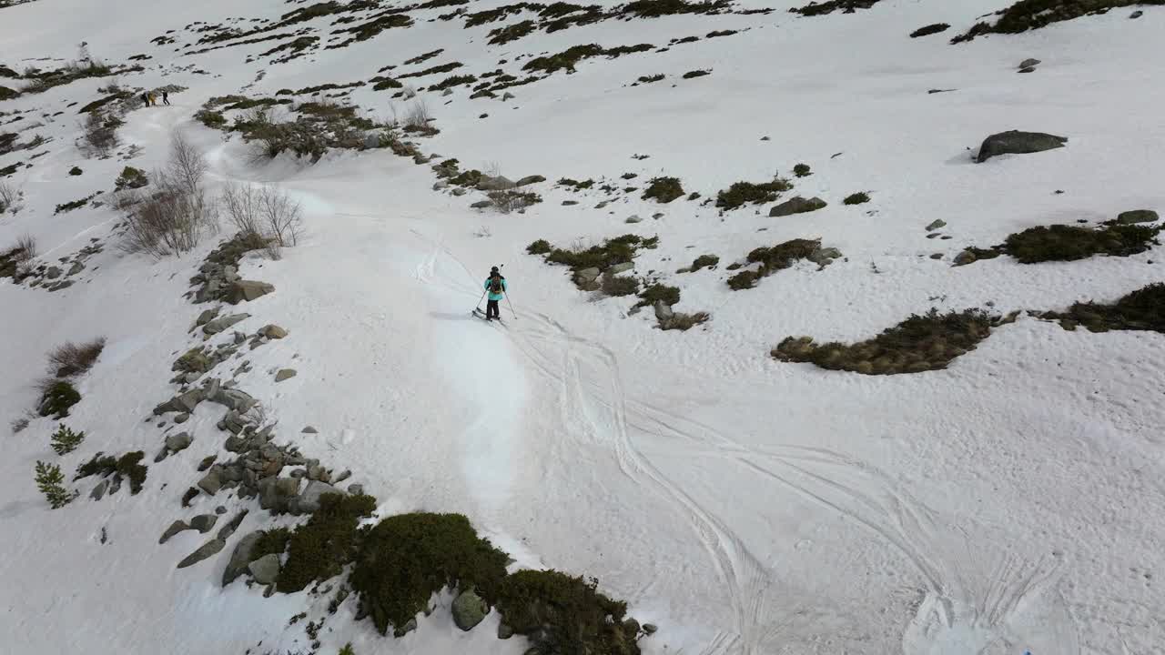 鸟瞰滑雪自由式滑雪者在雪山的高处在朋友的陪伴下下坡视频下载