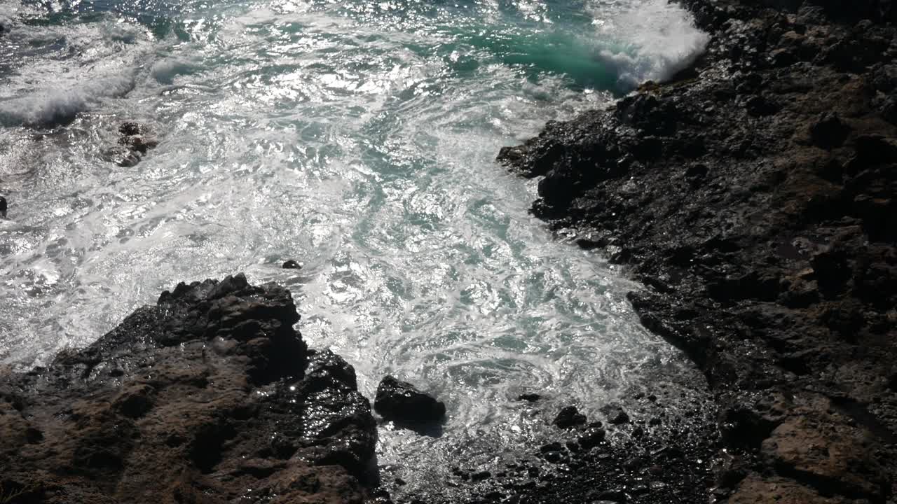 海浪和海浪冲击着海岸上的岩石。崎岖的海岸线，体现了大自然的力量和海边风景的宁静。视频下载