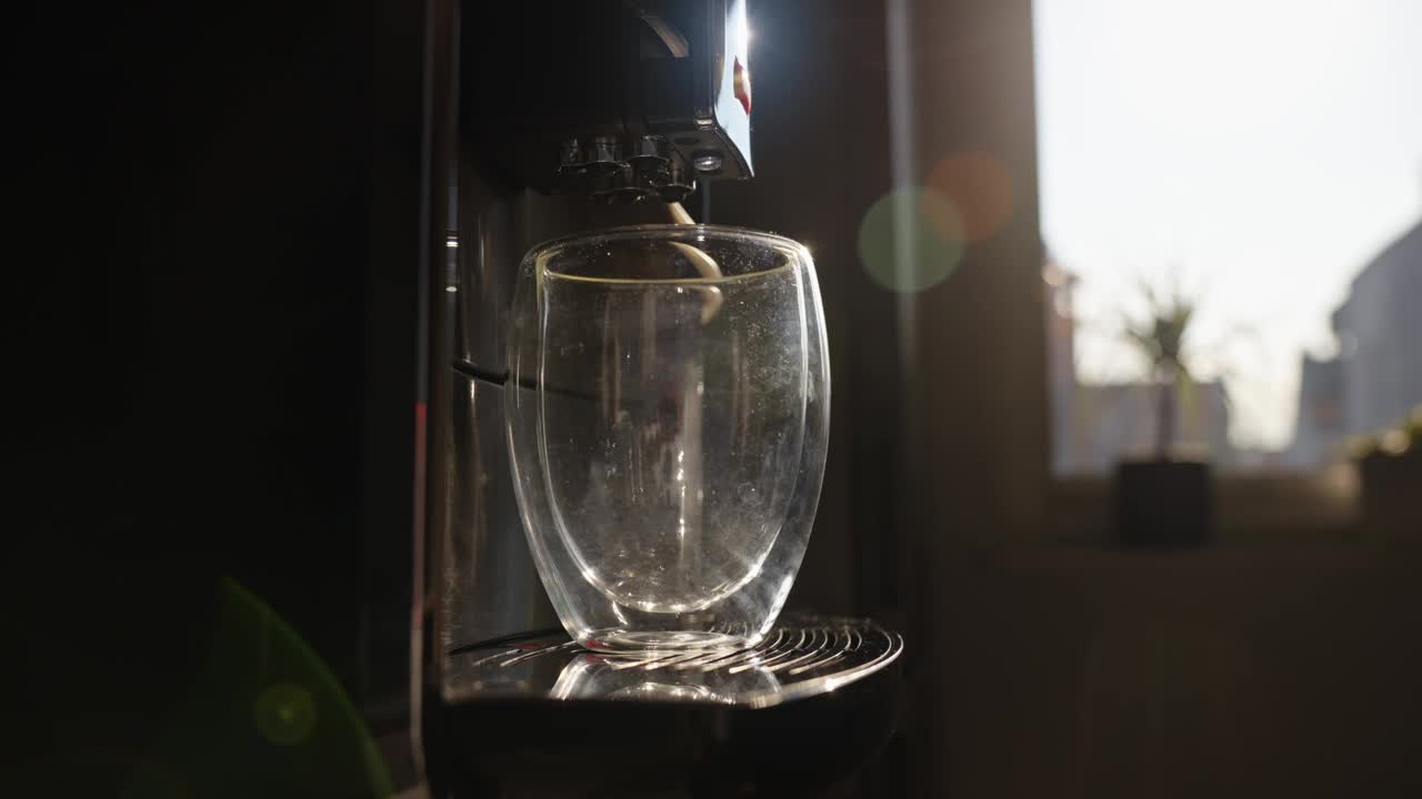 咖啡机在早晨的阳光下用玻璃杯冲咖啡视频下载
