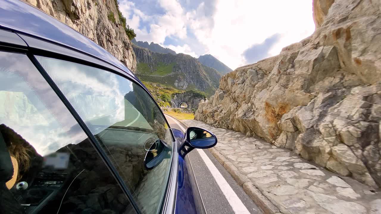 汽车行驶在雄伟空旷的蜿蜒山路上，俯瞰瀑布视频下载