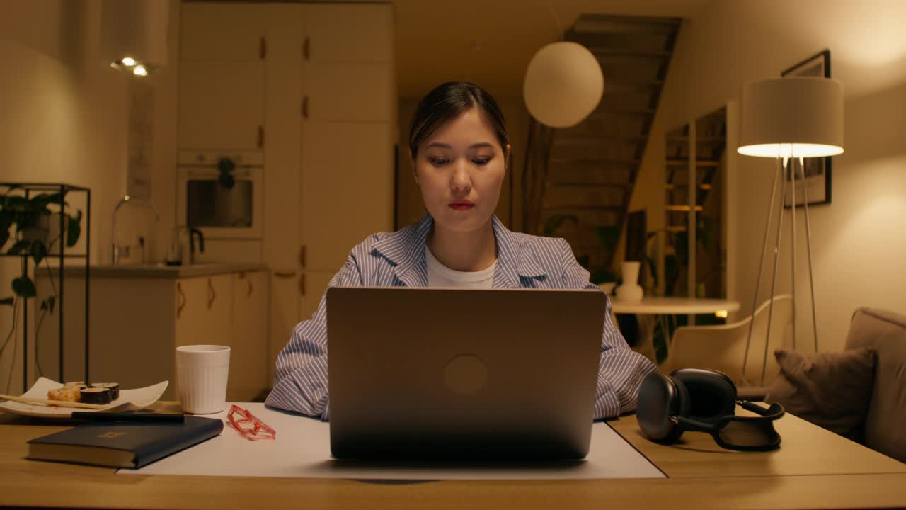 一个女人在家里使用笔记本电脑视频下载