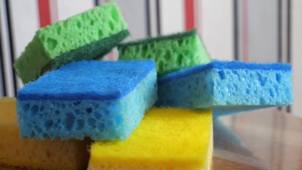 多色毛巾，用于洗碗和在旋转表面清洁，宏视频。绿色，蓝色和黄色的海绵。视频下载