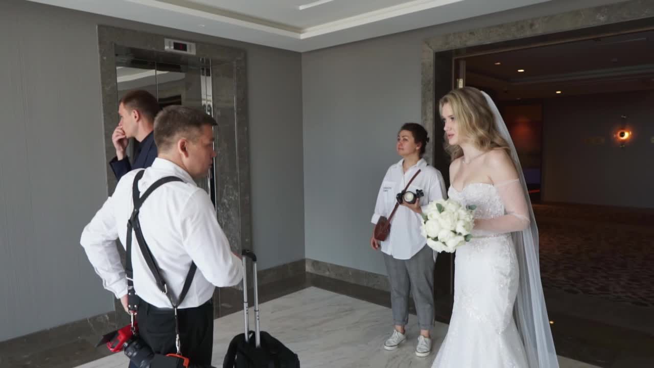新娘和新郎的摄影师正在现场寻找拍照地点。视频下载