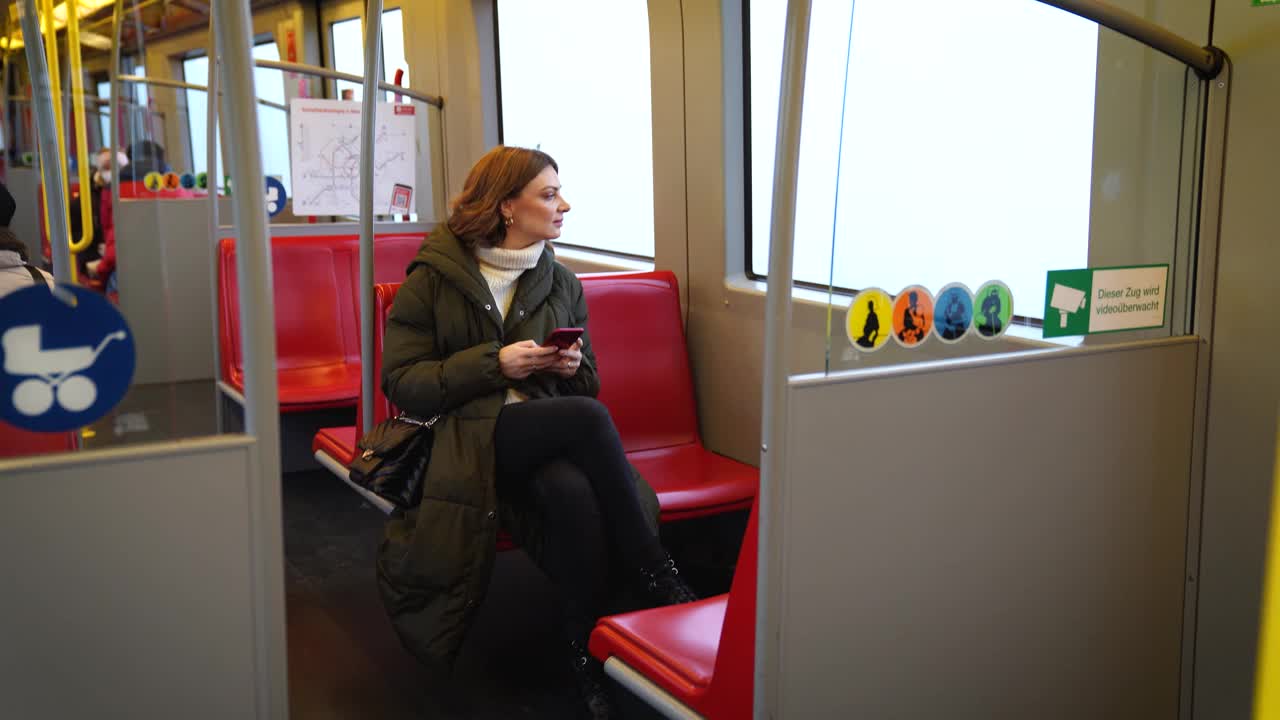 女子在乘坐地铁时使用智能手机视频下载