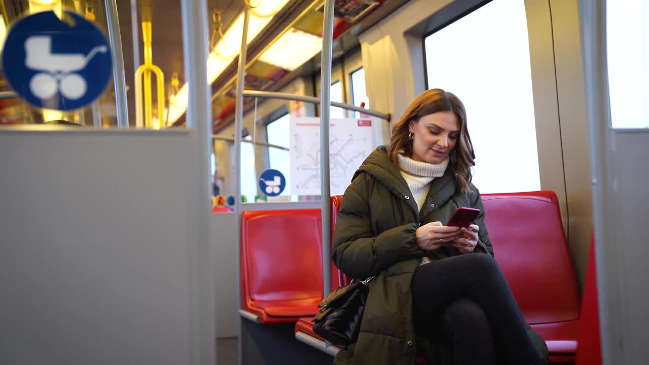 女子在乘坐地铁时使用智能手机视频下载
