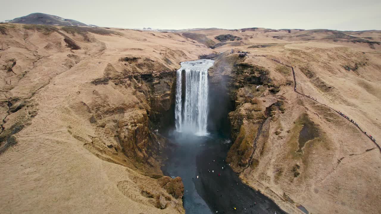 气势磅礴的斯科加弗斯瀑布在冰岛的秋天从棕色山脉的悬崖上流下视频下载