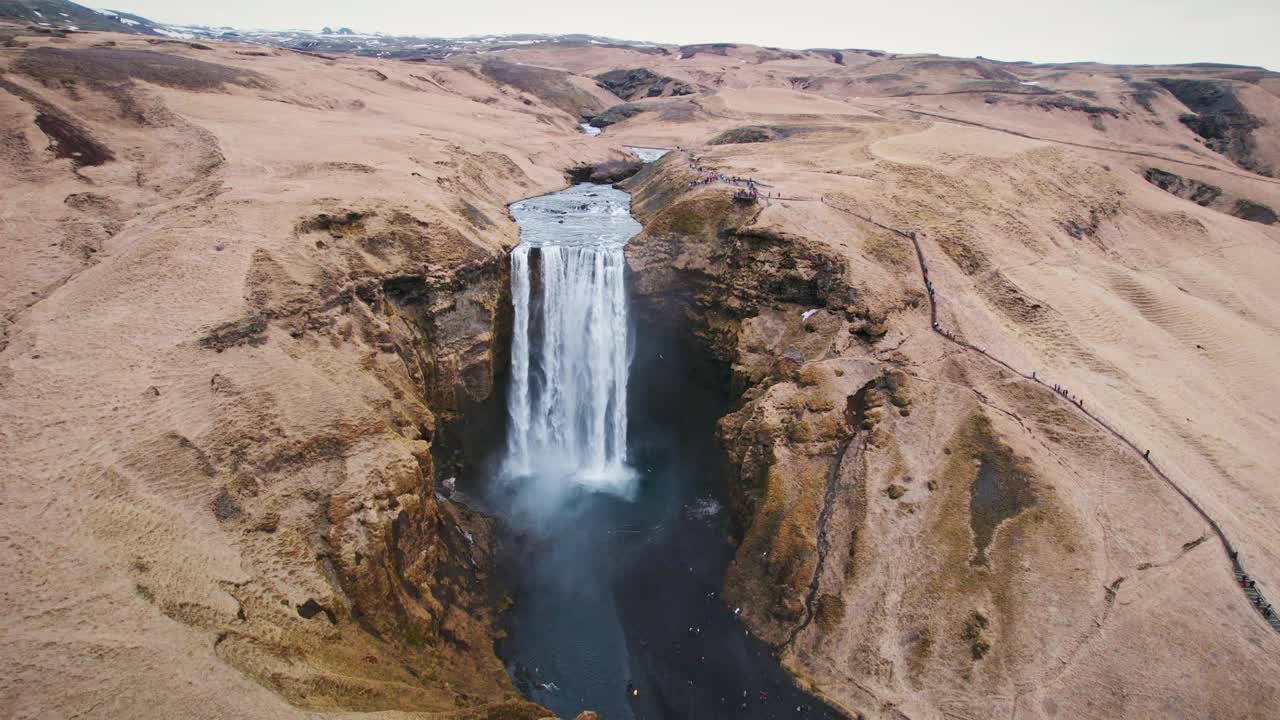 气势磅礴的斯科加弗斯瀑布在冰岛的秋天从棕色山脉的悬崖上流下视频下载
