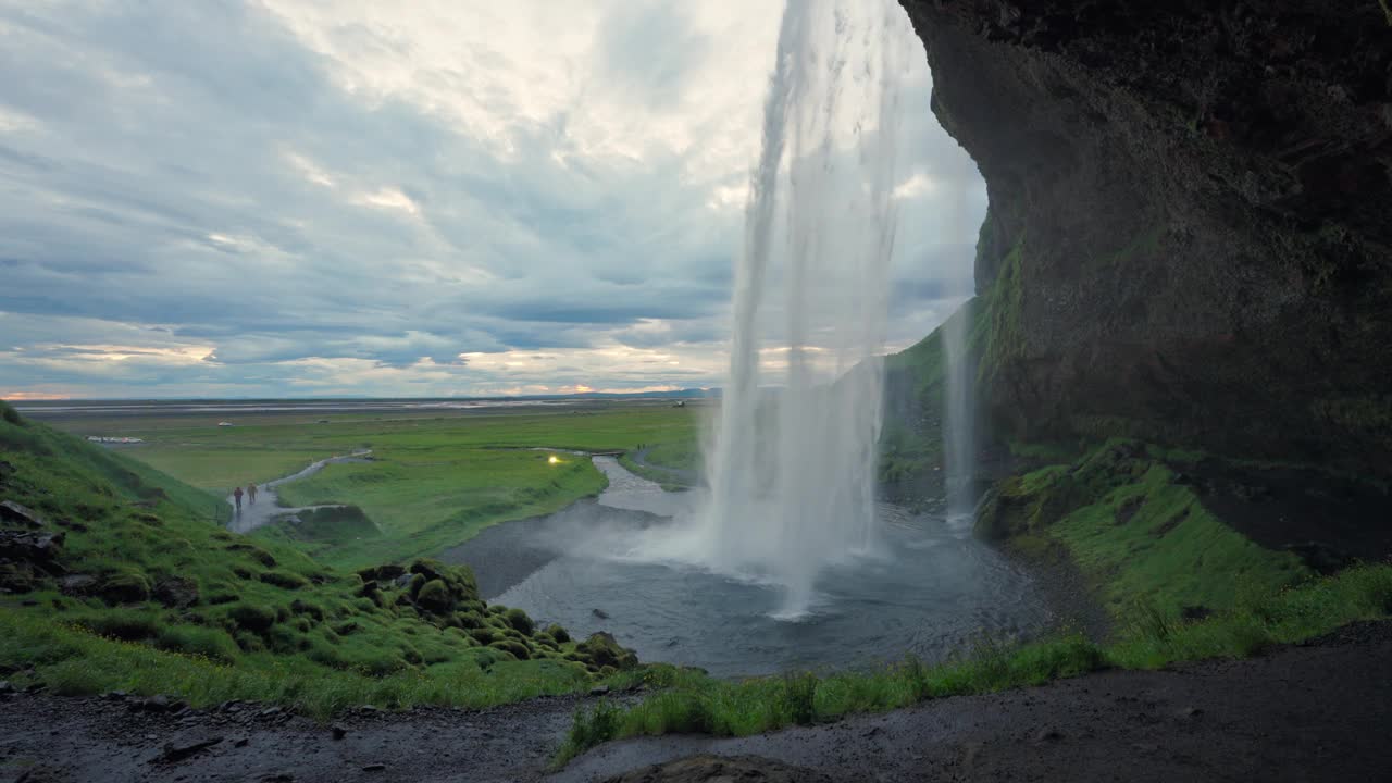 夏季，冰岛的Seljalandsfoss瀑布从石洞的悬崖上流下视频下载
