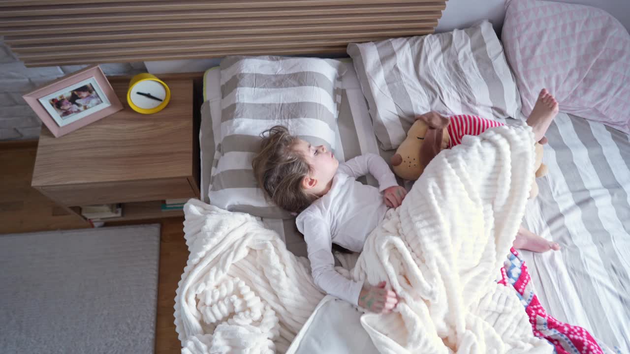 一个白人小女孩在床上睡觉的高角度照片视频下载