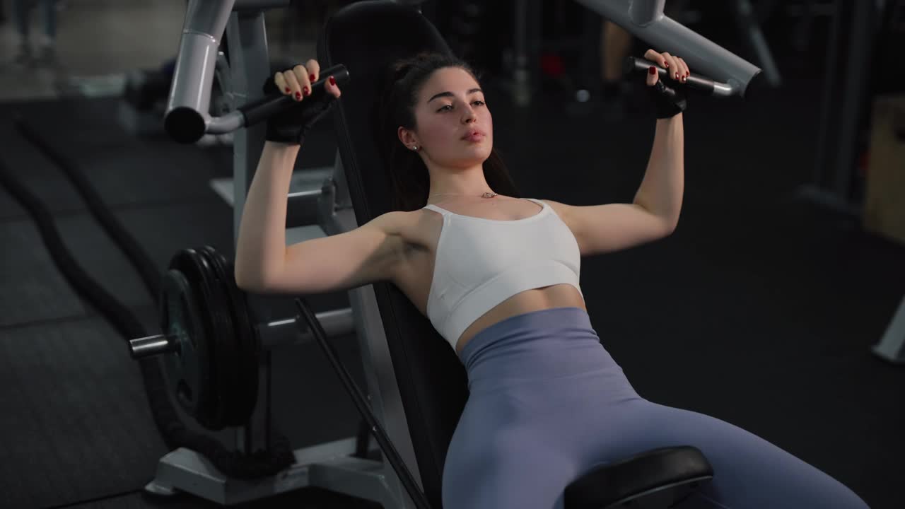 妇女在训练器械上做胸部锻炼视频下载