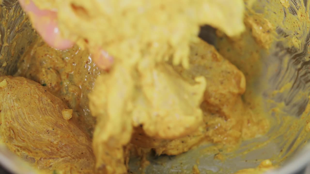 男子在炖锅中腌制鸡肉，准备印度菜鸡肉香饭，特写镜头视频下载