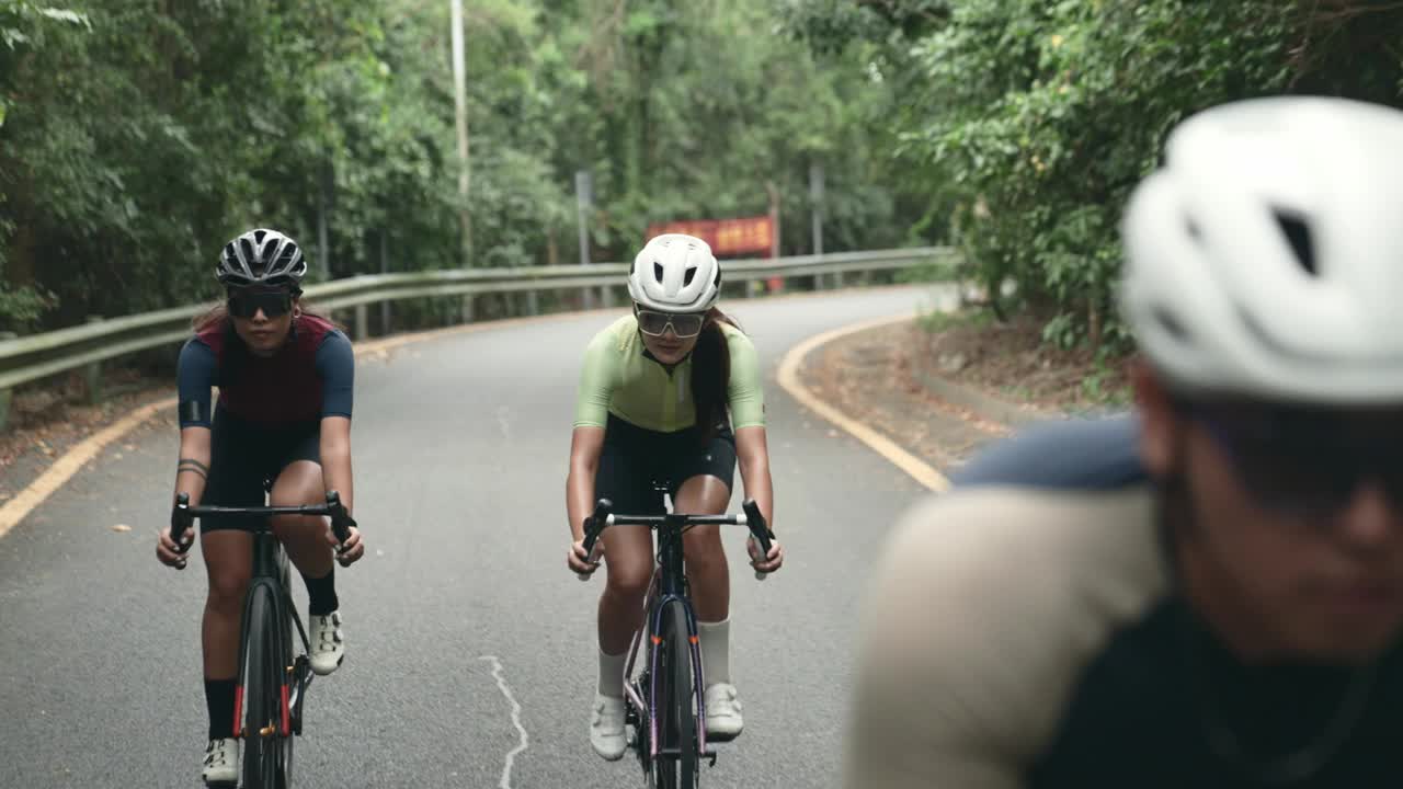 年轻的亚洲成年人在乡村道路上骑自行车视频下载