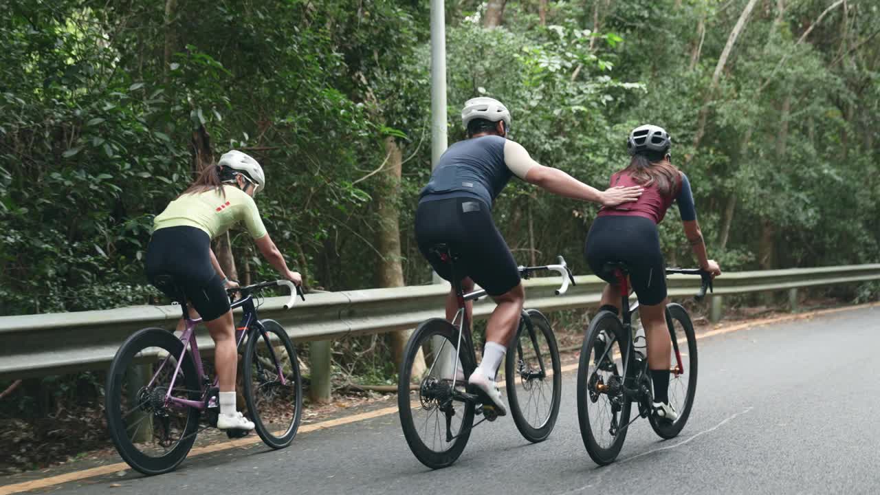 年轻的亚洲自行车手在乡村道路上骑自行车视频下载