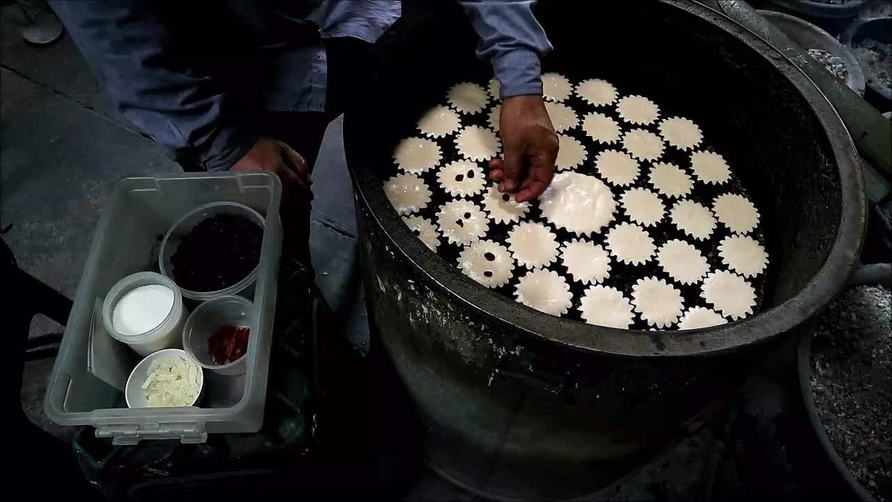 泰国著名的受葡萄牙影响的蛋糕Khanom Farang Kudeejeen，面包师在烤到一半的面糊上添加葡萄干的镜头视频下载