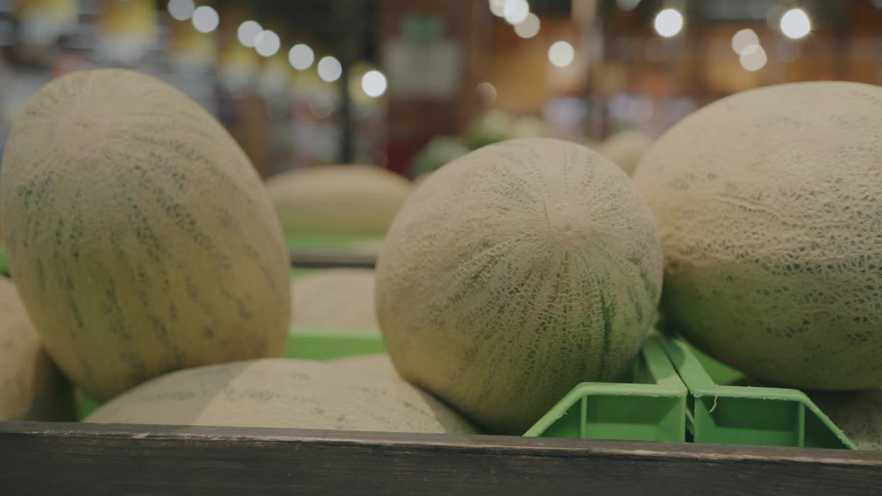 在繁忙的超市里，货架上准备出售的新鲜熟瓜特写视频下载