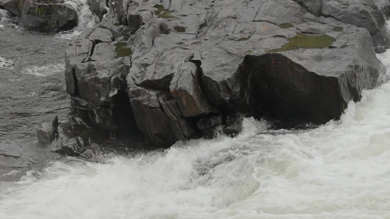 在爱沙尼亚，湍急的河流冲击着岩石海岸视频下载