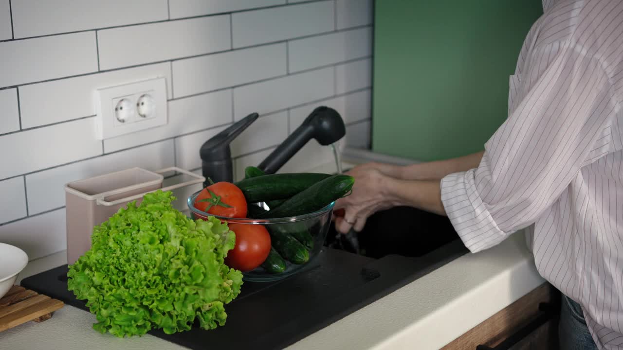 女性洗手清洗新鲜有机蔬菜的特写视频下载